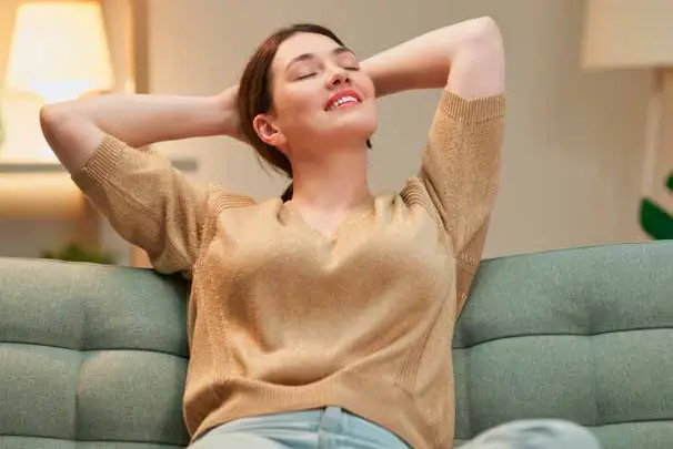 Mulher relaxando no sofá, num ambiente silencioso
